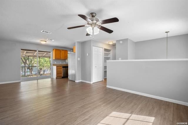 unfurnished living room with dark wood-type flooring and ceiling fan