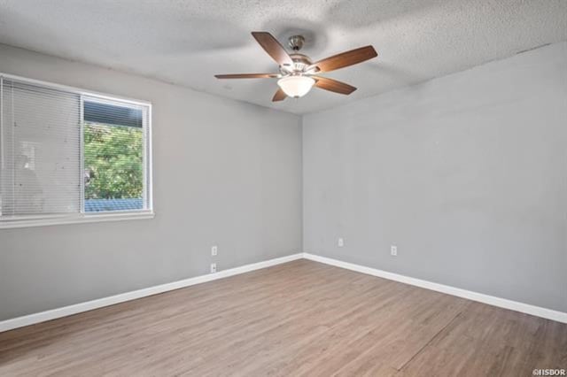 spare room featuring ceiling fan, hardwood / wood-style floors, and a textured ceiling