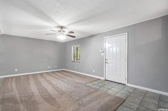 carpeted empty room featuring a textured ceiling and ceiling fan