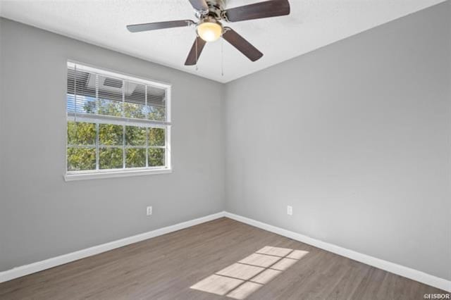 unfurnished room with ceiling fan and dark hardwood / wood-style flooring