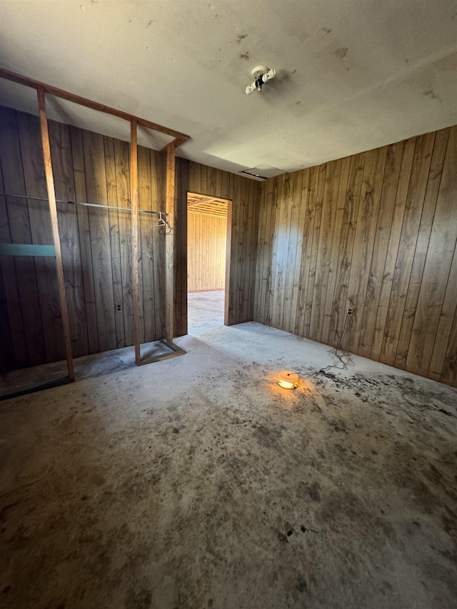 unfurnished bedroom featuring wooden walls