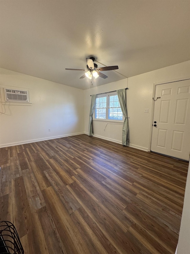 empty room featuring a wall unit AC, dark wood-type flooring, and ceiling fan