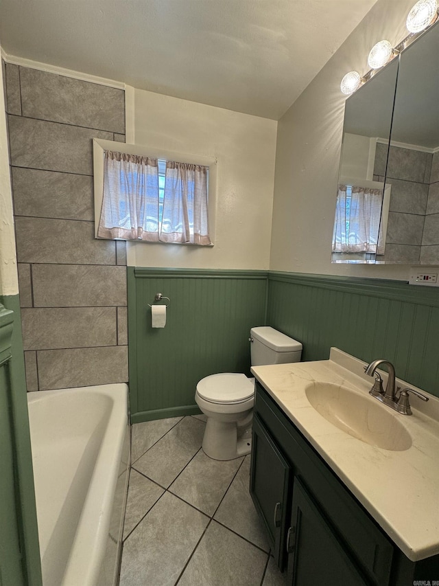 bathroom featuring toilet, vanity, tile patterned flooring, and a bath