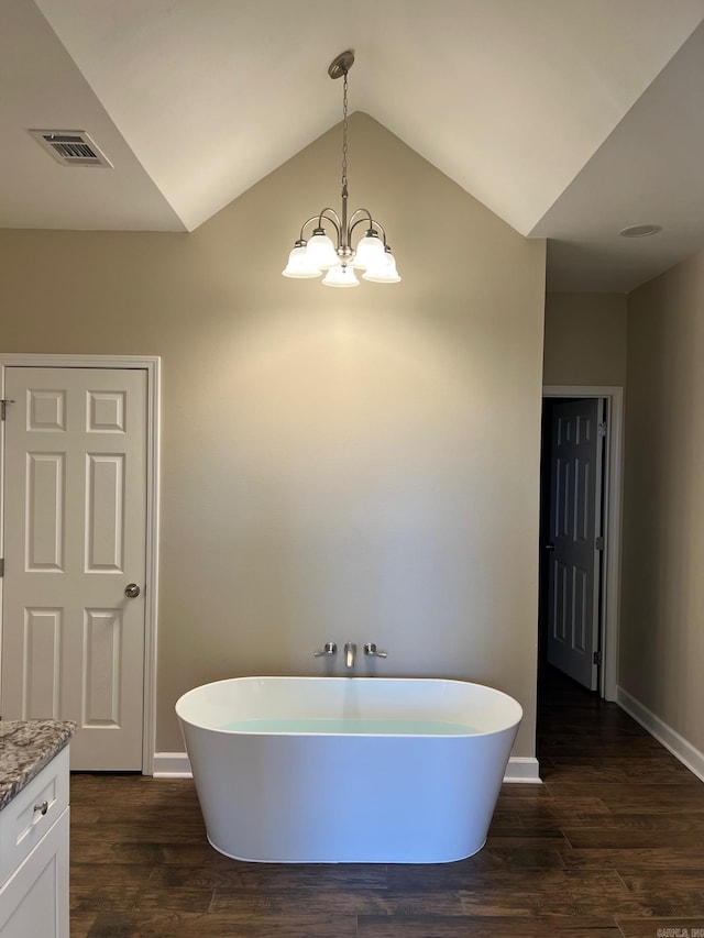 bathroom featuring vanity, a tub to relax in, hardwood / wood-style floors, and lofted ceiling