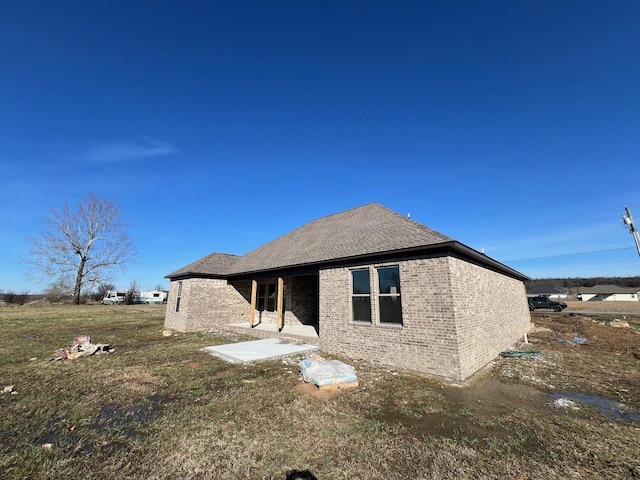 back of property with a patio area and a lawn