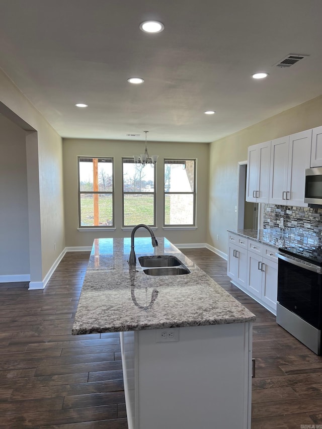 kitchen with sink, white cabinetry, a kitchen island with sink, stainless steel appliances, and light stone counters