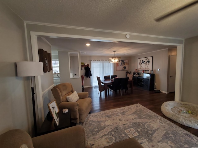 living room featuring crown molding, dark wood-type flooring, a wealth of natural light, and a textured ceiling
