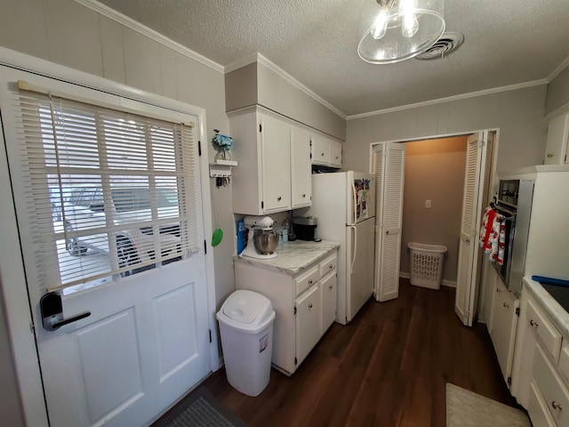 kitchen with a textured ceiling, white refrigerator, ornamental molding, dark hardwood / wood-style floors, and white cabinets