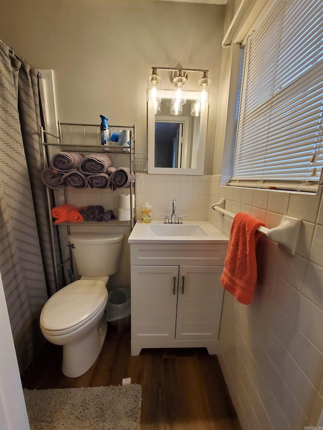 bathroom with tile walls, vanity, hardwood / wood-style floors, and toilet