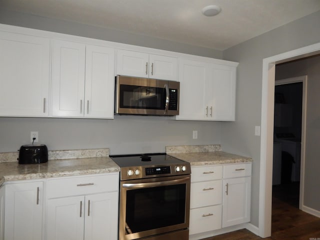 kitchen featuring dark wood-type flooring, stainless steel appliances, and white cabinets