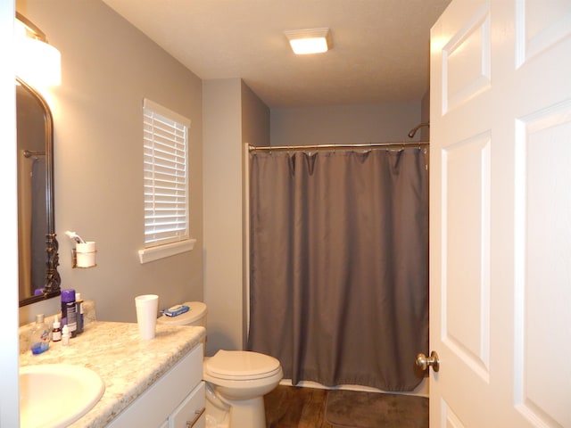 bathroom featuring a shower with curtain, vanity, wood-type flooring, and toilet