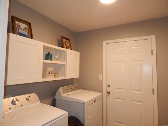 clothes washing area featuring cabinets and washer and dryer