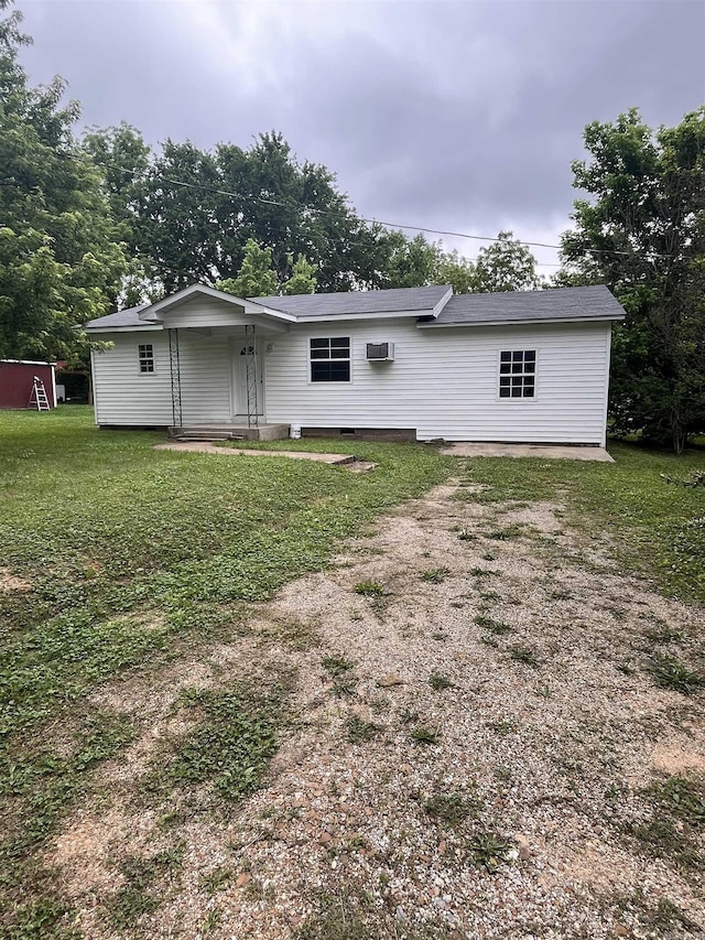 back of house featuring an AC wall unit and a yard