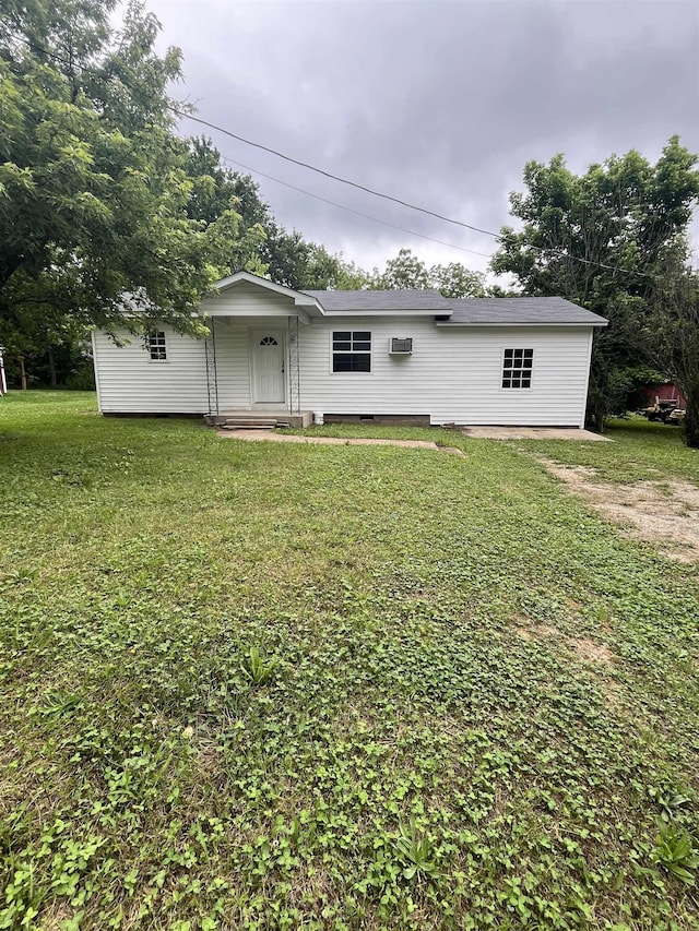 rear view of property featuring a lawn