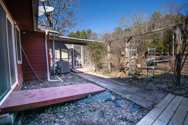 view of yard with a sunroom and central AC