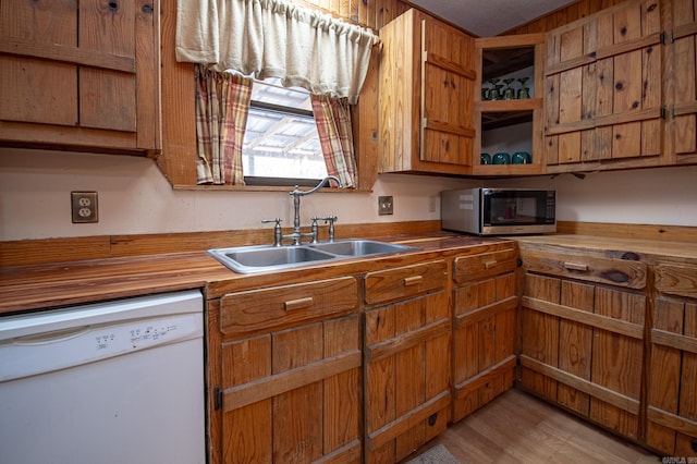 kitchen with dishwasher, sink, butcher block counters, and light hardwood / wood-style floors