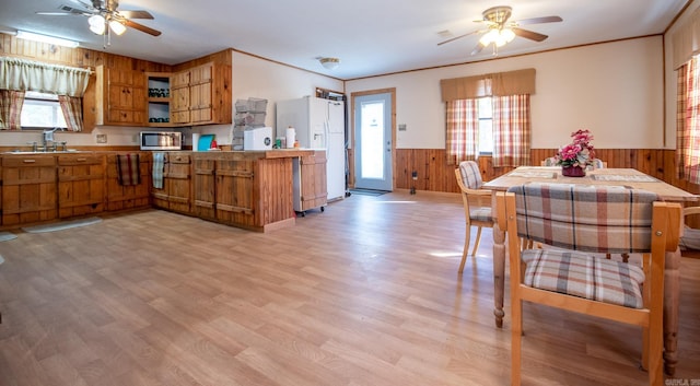 kitchen featuring light hardwood / wood-style flooring, white refrigerator with ice dispenser, kitchen peninsula, and ceiling fan