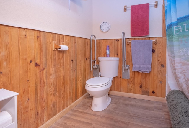 bathroom featuring hardwood / wood-style flooring, toilet, and wood walls