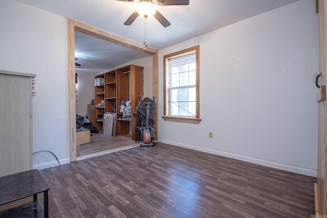 unfurnished living room with dark wood-type flooring and ceiling fan