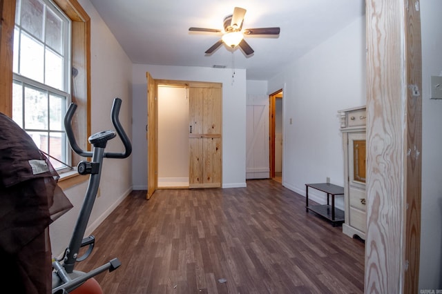 exercise area with ceiling fan and dark hardwood / wood-style floors