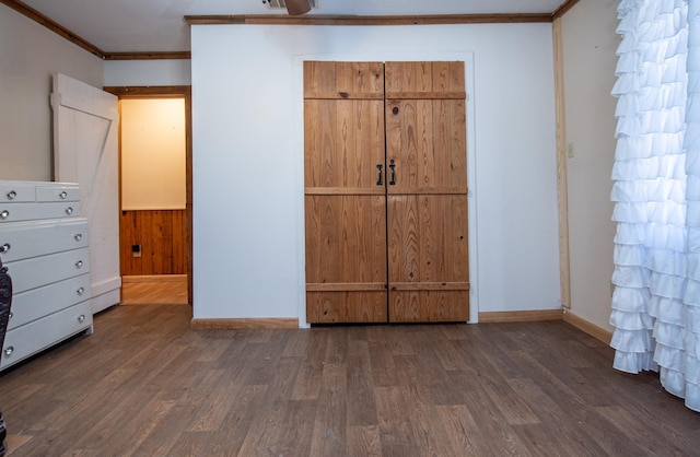 unfurnished bedroom featuring dark wood-type flooring and ornamental molding