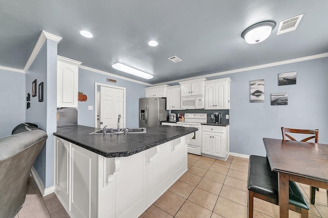 kitchen with sink, white appliances, kitchen peninsula, and white cabinets