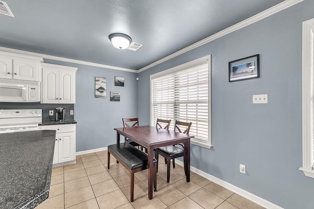 dining space featuring crown molding and light tile patterned floors