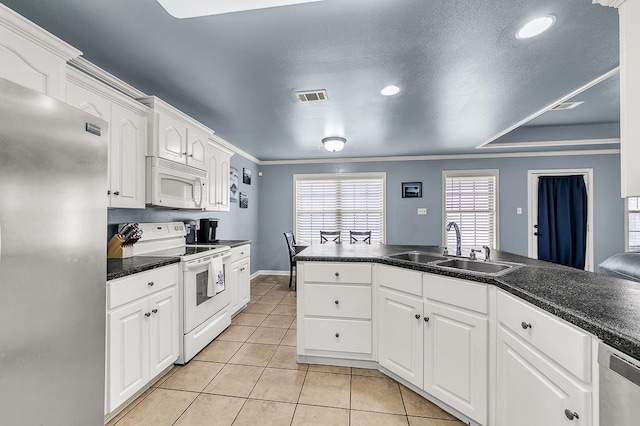 kitchen with sink, light tile patterned floors, appliances with stainless steel finishes, a textured ceiling, and white cabinets