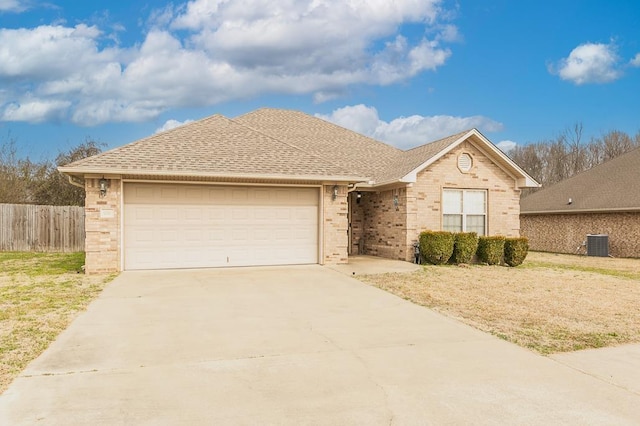 ranch-style house with cooling unit, a garage, and a front lawn