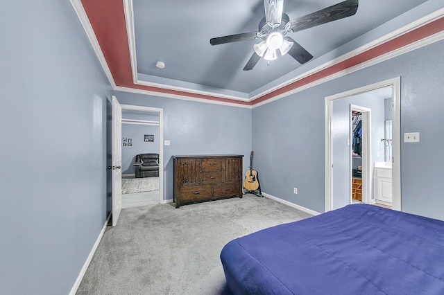 carpeted bedroom featuring crown molding, a raised ceiling, and ceiling fan