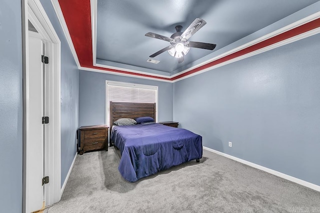 bedroom with carpet flooring, ceiling fan, and a tray ceiling