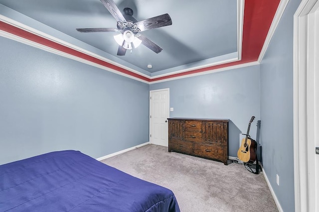 bedroom featuring ornamental molding, light colored carpet, a raised ceiling, and ceiling fan