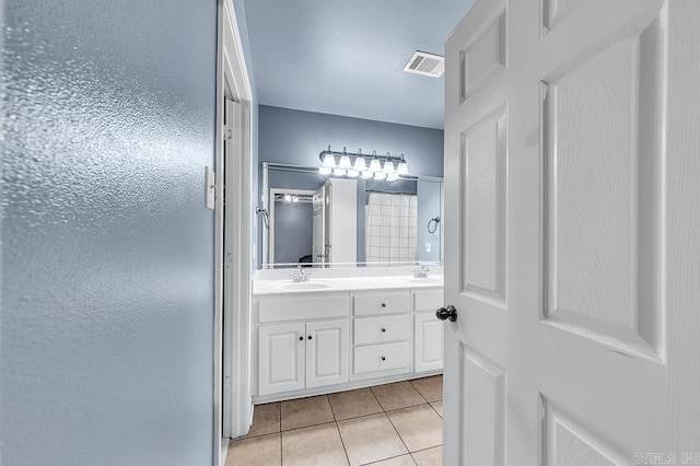 bathroom with vanity, tile patterned flooring, and a shower