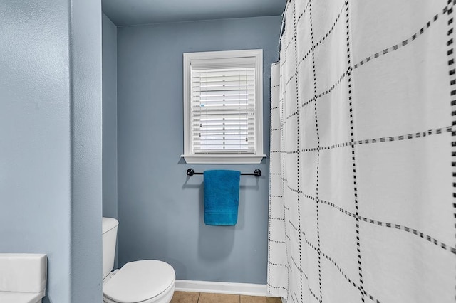 bathroom featuring walk in shower, tile patterned floors, and toilet