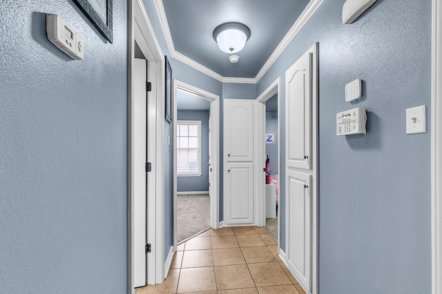 hallway with crown molding and light tile patterned flooring