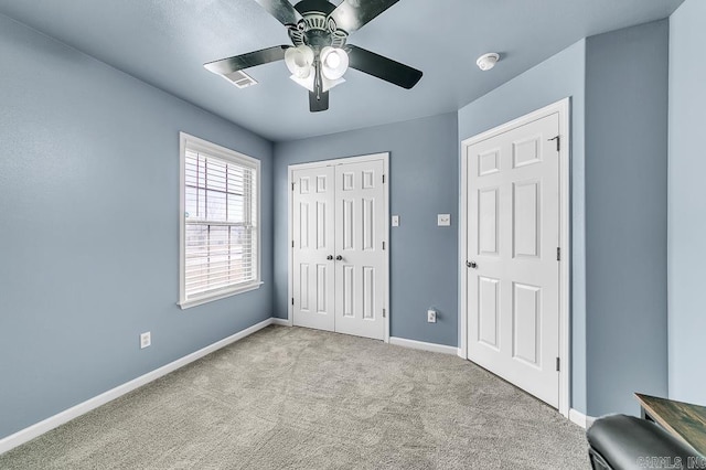 unfurnished bedroom with ceiling fan, a closet, and light carpet