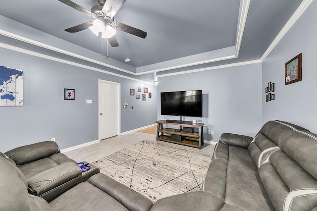 living room featuring crown molding, ceiling fan, a tray ceiling, and hardwood / wood-style flooring