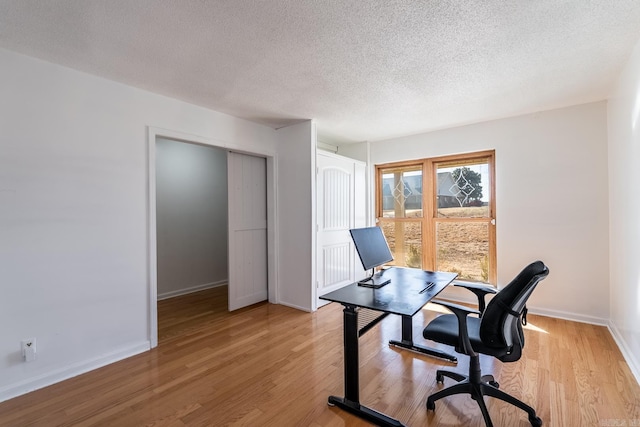 home office featuring a textured ceiling and light wood-type flooring