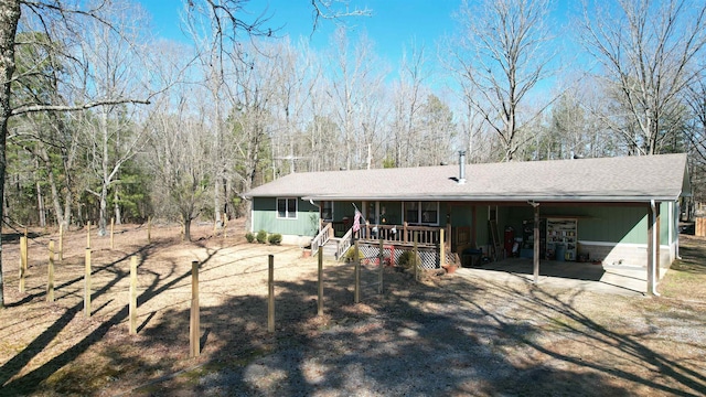 rear view of property with a carport and a porch