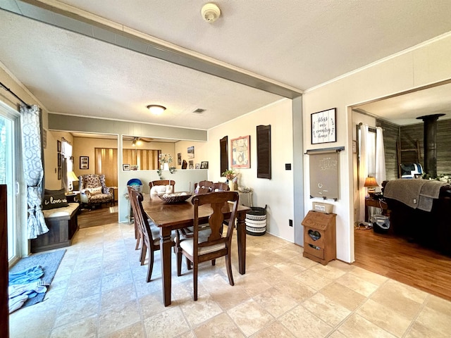 dining area featuring ceiling fan, ornamental molding, and a textured ceiling