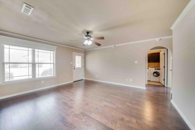 unfurnished living room with crown molding, dark wood-type flooring, washer and clothes dryer, and ceiling fan