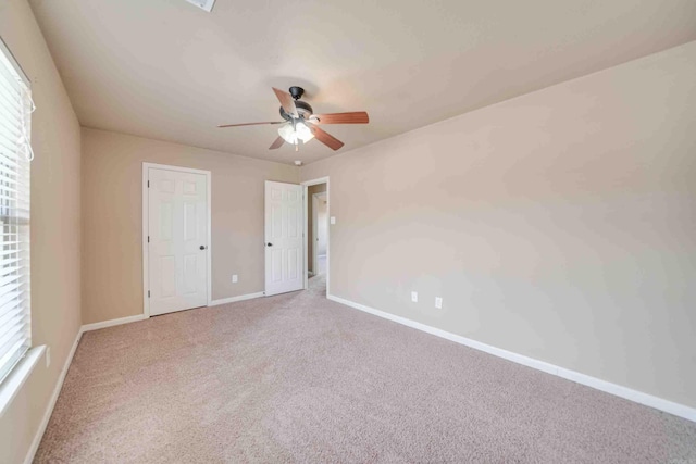 unfurnished bedroom with ceiling fan, carpet flooring, and multiple windows