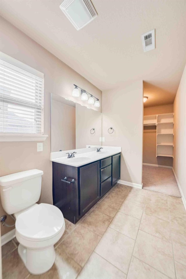 bathroom with tile patterned flooring, vanity, and toilet