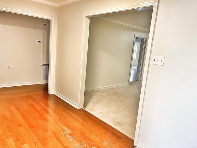 corridor featuring ornamental molding and hardwood / wood-style floors