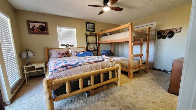 bedroom featuring multiple windows, light carpet, and a textured ceiling