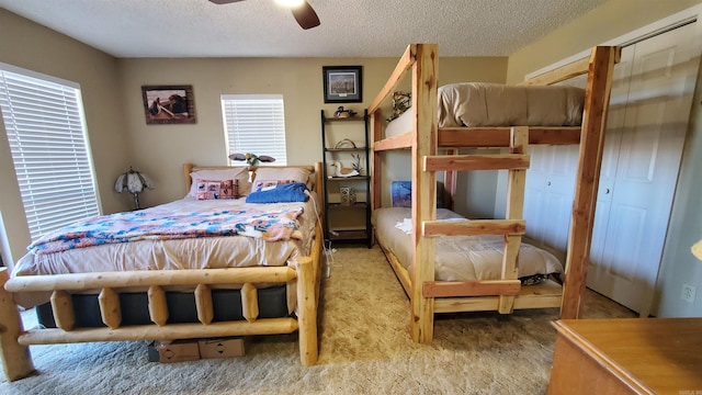 bedroom with multiple windows, ceiling fan, and a textured ceiling