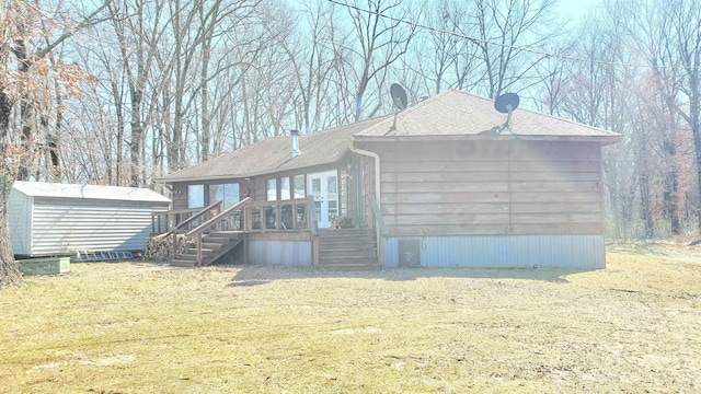 view of front of home featuring a storage unit and a front yard