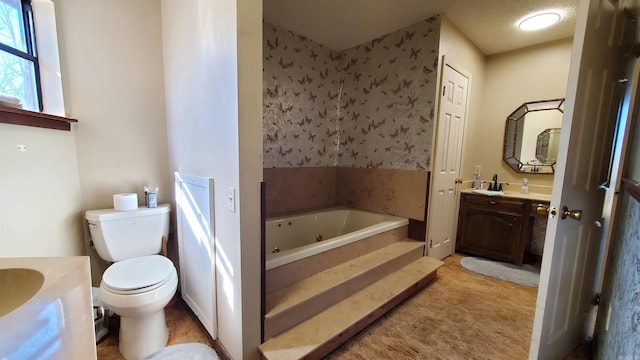 bathroom with a tub to relax in, vanity, and toilet