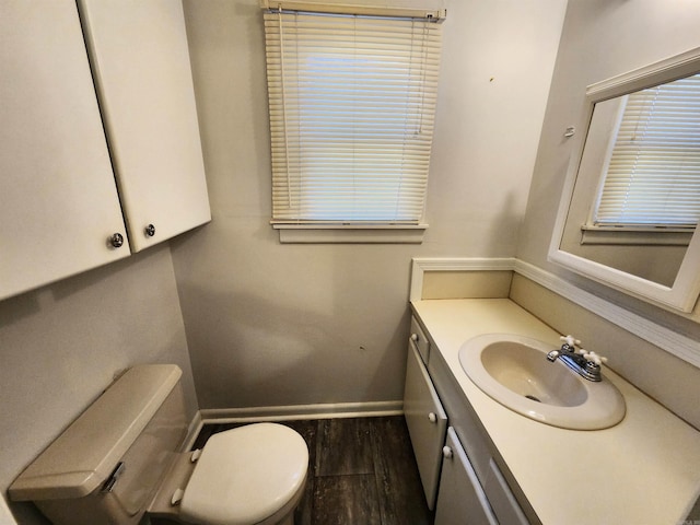 bathroom with vanity, toilet, and hardwood / wood-style floors