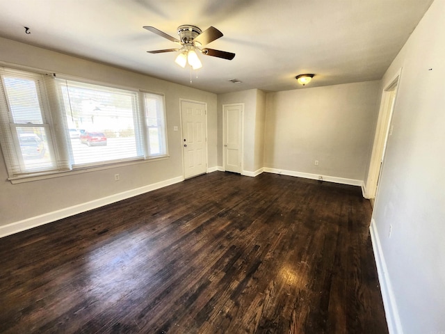 empty room with ceiling fan and dark hardwood / wood-style flooring